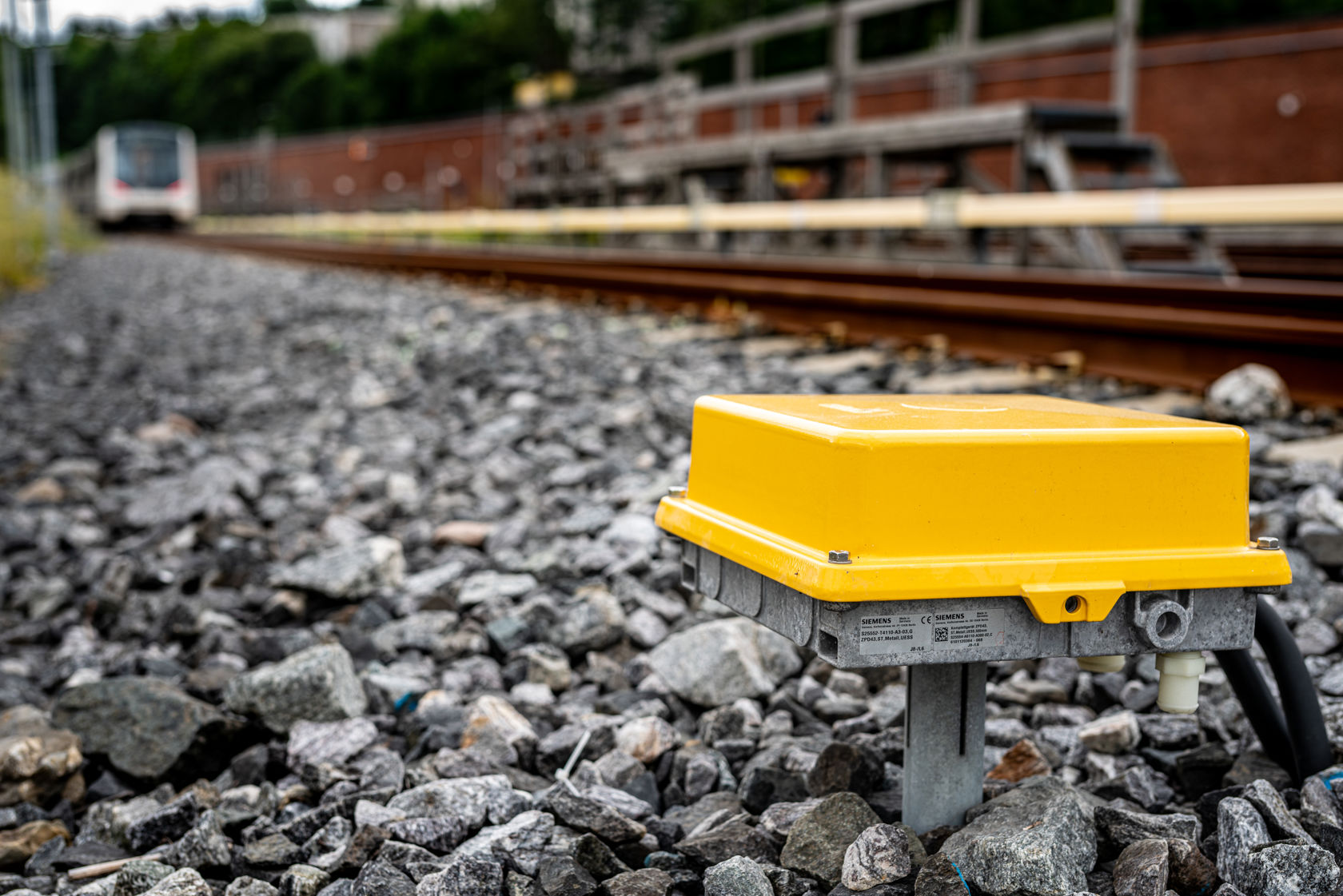 Bildet er tatt fra bakkenivå. Det er en T-bane i bakgrunnen, med en gul boks i forgrunnen som er uthevet.