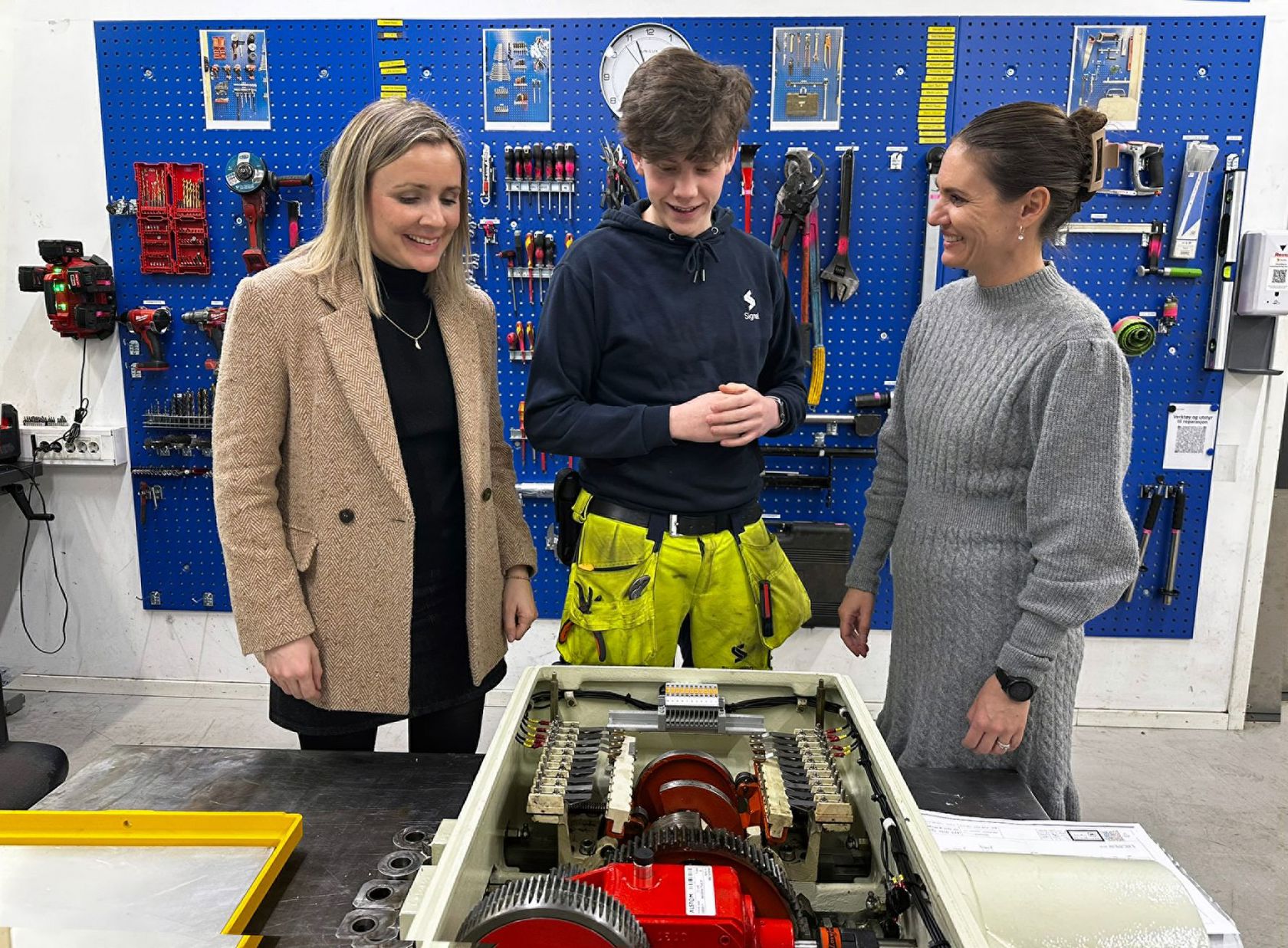 Sporveiens signalmontørlærling, Herman Osvold Askheim forklarer byråd for miljø og samferdsel Marit Vea (V) og byråd for utdanning Julie Remen Midtgarden (H) om signalsystemet og demonstrerte hvordan en drivmaskin fungerer mekanisk.