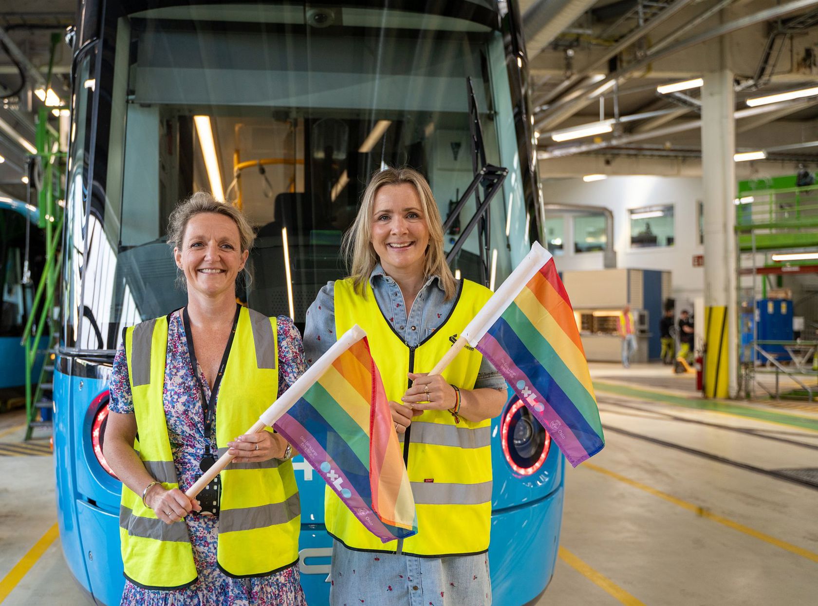 Birte Sjule, konsernsjef i Sporveien og Marit Vea, byråd for Miljø og Samferdsel, setter de første av mange hundre pride-flagg på trikken i Oslo